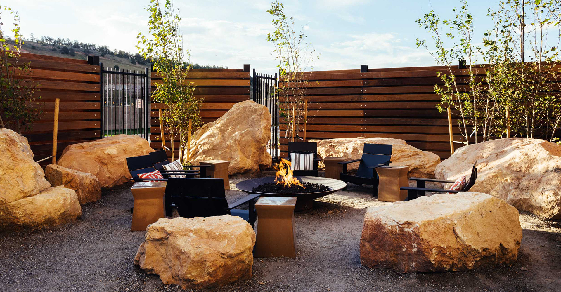 Outside lounge area with a fire pit in the middle and rocks surrounding