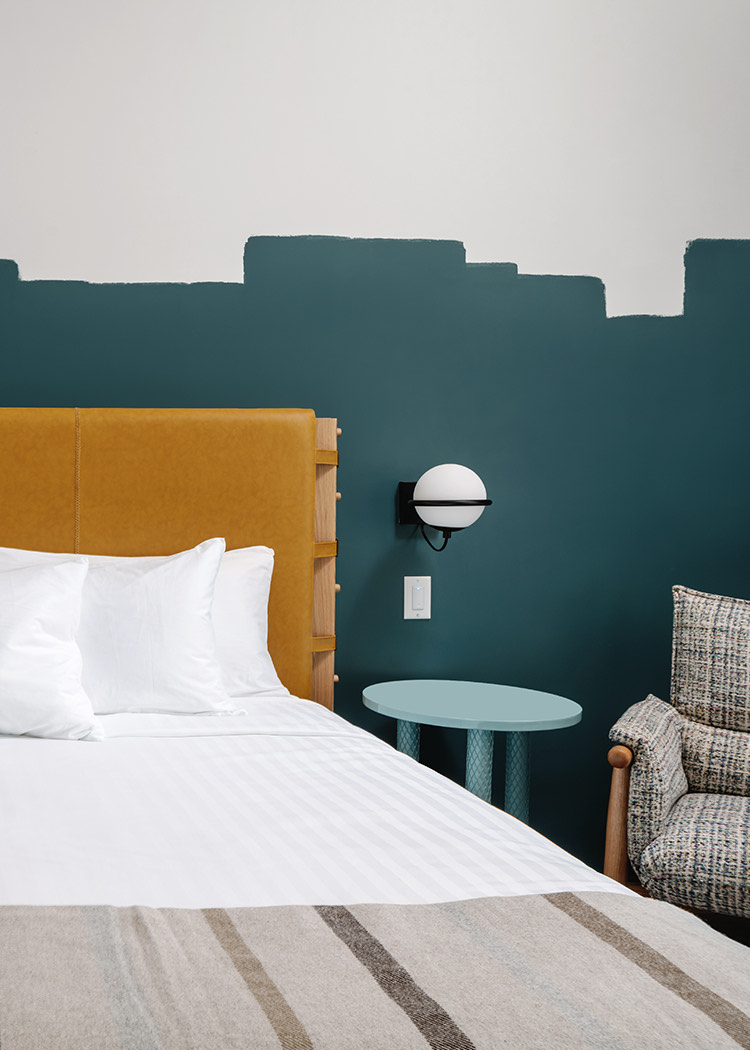 hotel room with teal walls and a yellow headboard