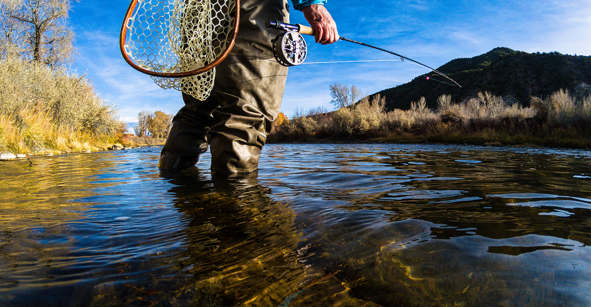 angle of man's feet in water fishing