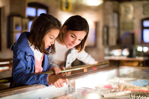 mother and daughter looking into glass case at museum