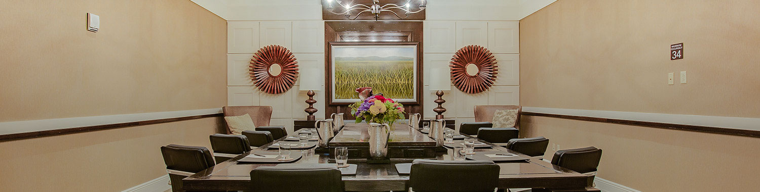 meeting venue with a screen at the front of the room and black chairs around a rectangular table