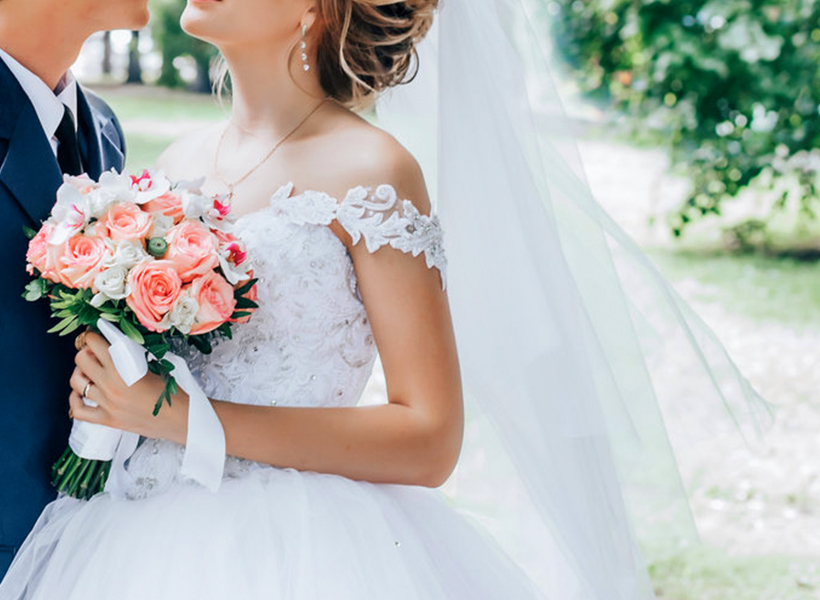close view of a bride holding a roses bucket