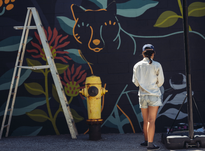 woman in front of mural