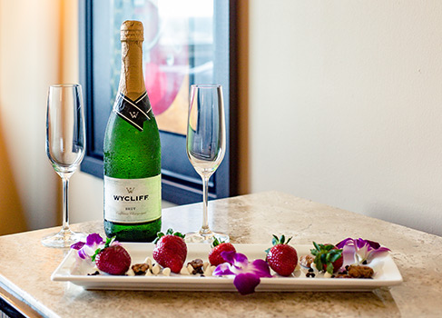 strawberries on a white platter with a champagne bottle and champagne flutes
