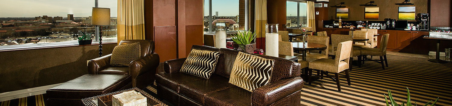breakfast dining area, tables with brown chairs, brown leather couches, coffee table, brown lounge chairs