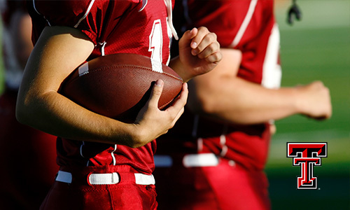 Texas Tech football players, one holding a football