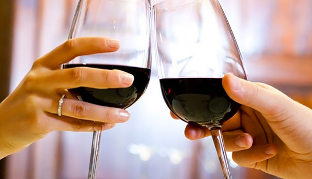 couple clinking two glasses of red wine