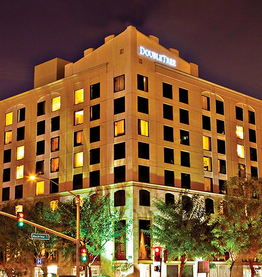Facade view of Doubletree hotel at nighttime and a traffic light