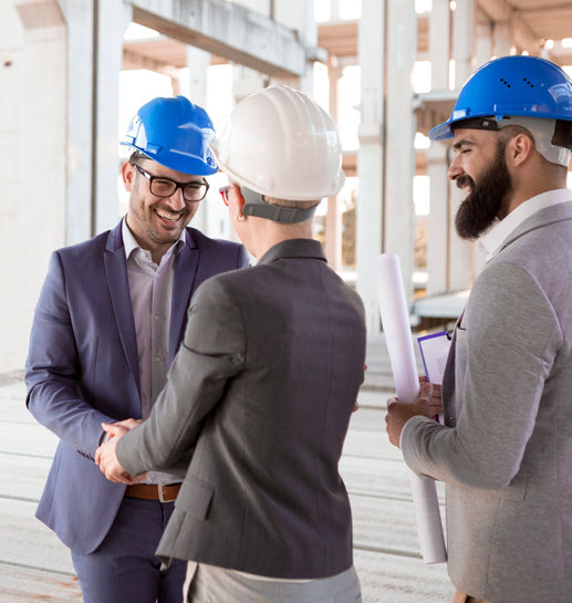 Three people in a construction making decision and laughing looking at each other
