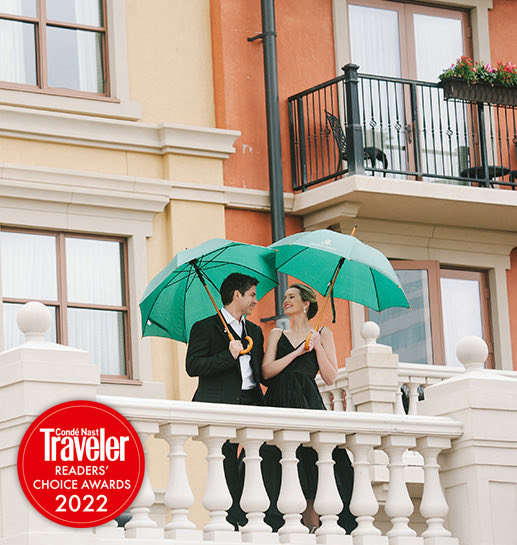 couple holding green umbrellas with the conde nast traveler readers choice awards 2022 logo on the bottom left