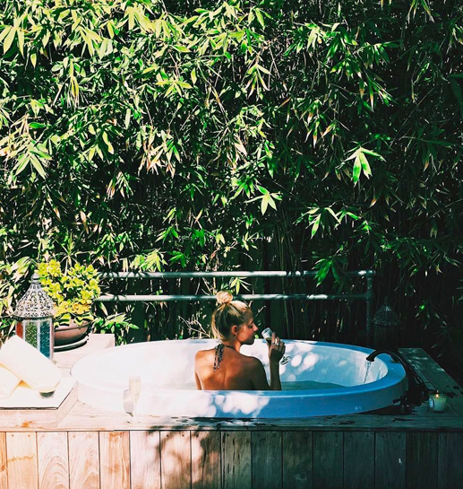 Young woman taking a sip at the sauna in a natural environment