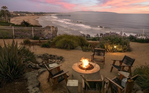 Fire pit with chairs around it at sunset