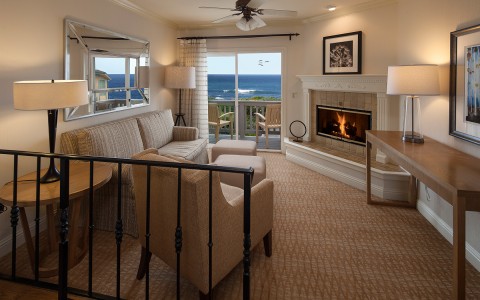 a guest room with a fireplace and ocean views