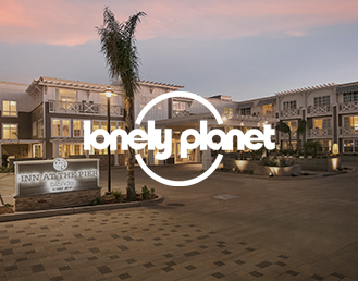 the exterior of a pacifica hotel at sunset