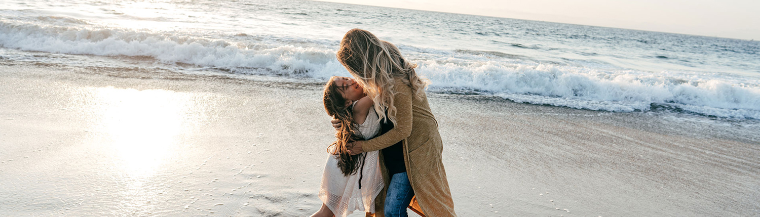 a mom and her child playing on the beach