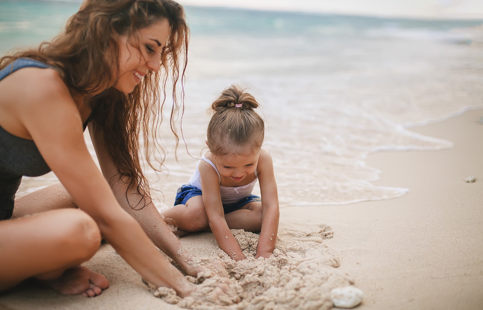 Mom and daughter playing in the sand