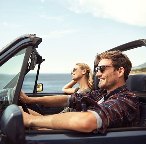 couple driving in a convertible car