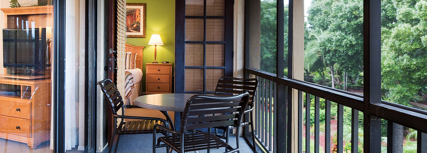 Room balcony with table & metallic chairs next to room & living room access