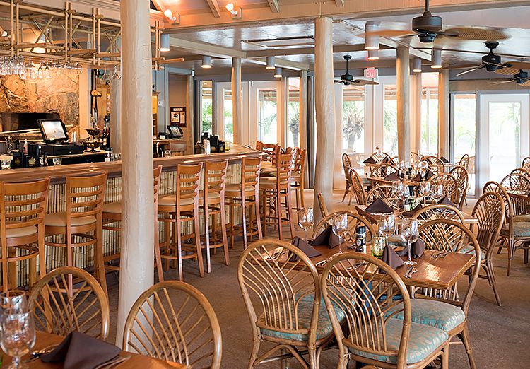 Pate's dining space with wooden tables with chairs & wooden stools at bar