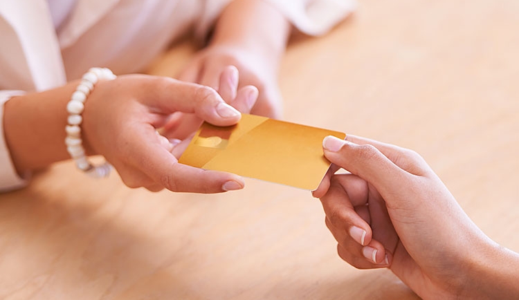 Close up of hand giving credit card to someone else