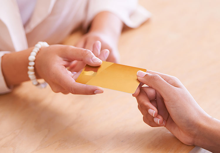 Close up of hand giving credit card to someone else