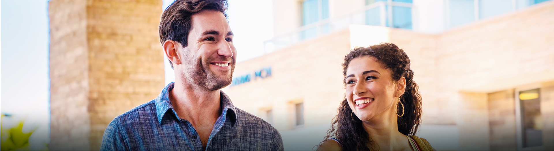 couple smiling in front of a building