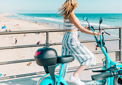 woman riding a motor bike next to the beach