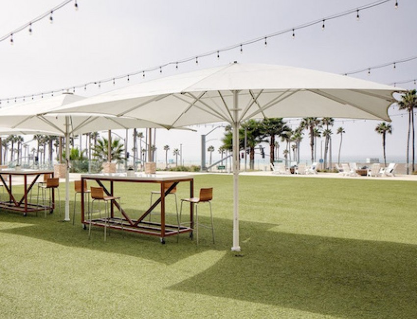 tables on the exterior with parasols and fairly lights