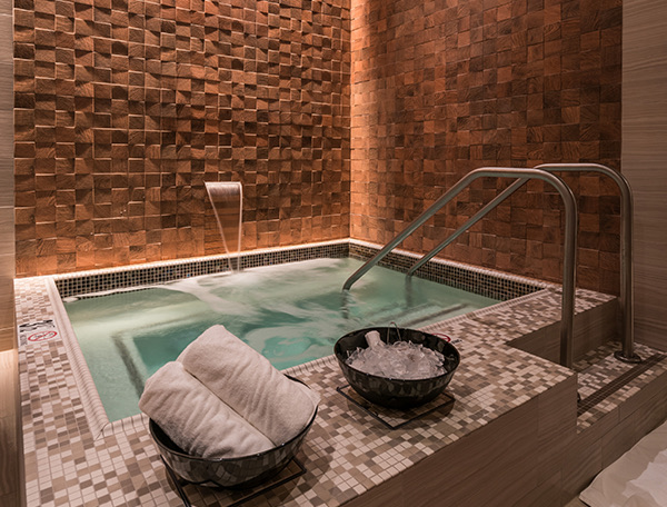 Spa room with a hot tub and towels