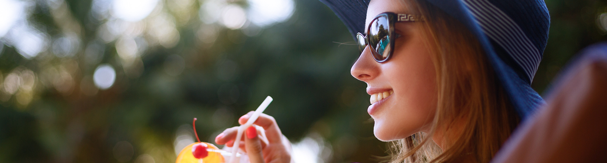 woman smiling while sipping a drink