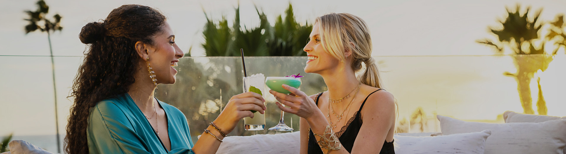 two women friends cheering with cocktails