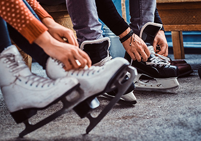 people tying up ice skating shoe laces