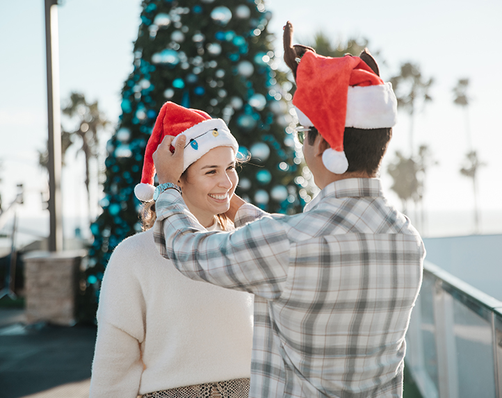 couple with santa hats on at the holiday ice rink