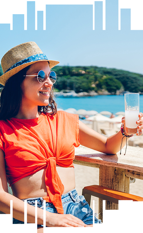 young woman in orange t-shirt enjoying a drink sitting outside