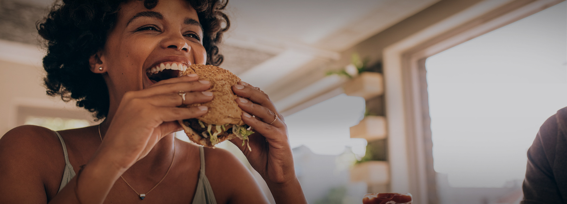 woman taking a bite from a juicy burger