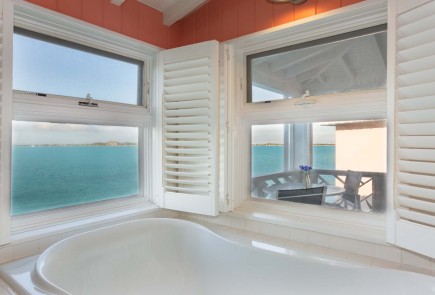 bath tub with a window behind it that has the beachfront view
