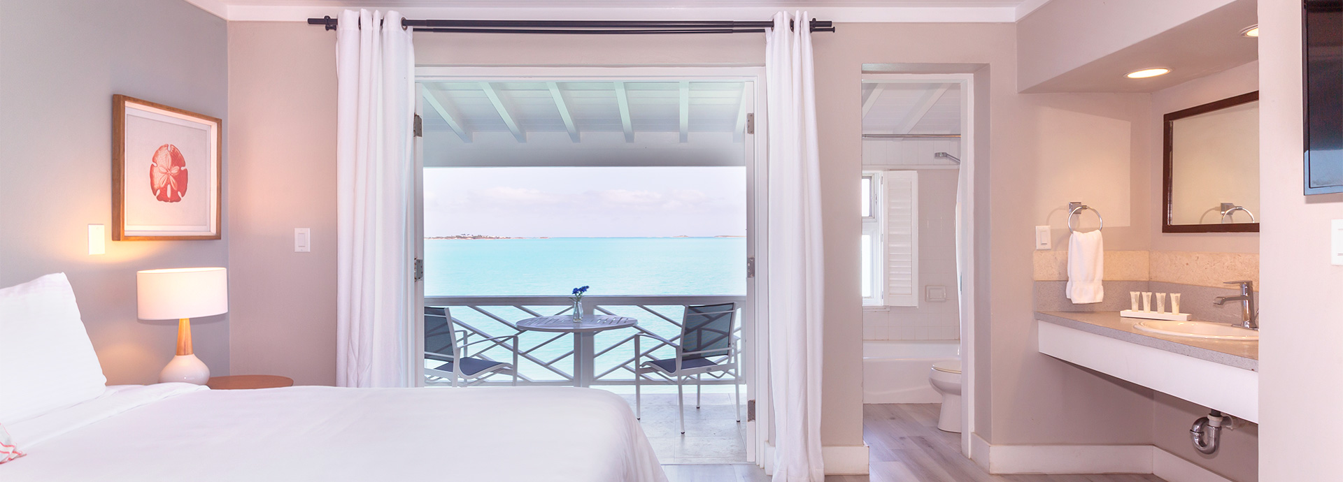 view of a hotel room with balcony and ocean view