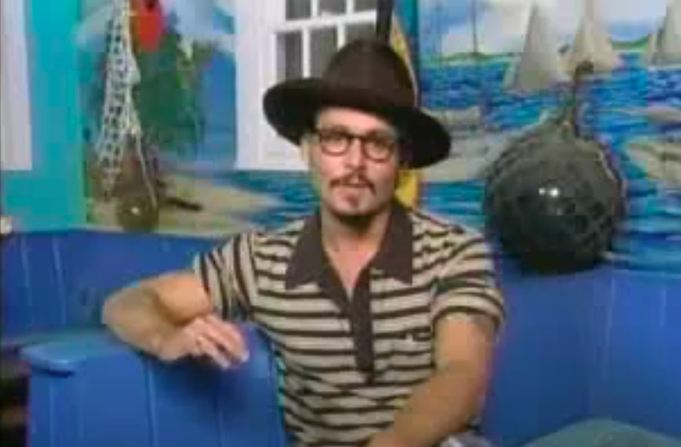 Johnny Depp wearing a hat and glasses during an interview