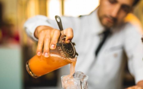 Bartender pouring drink in glass