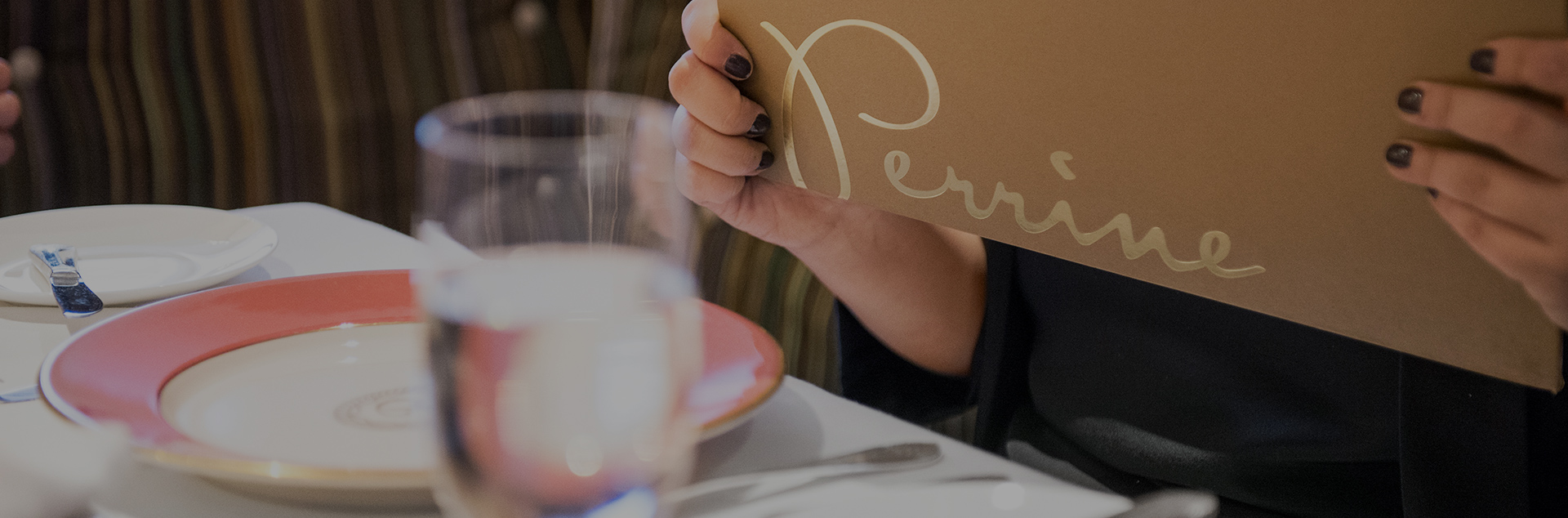 a woman reading the perrine menu at the table