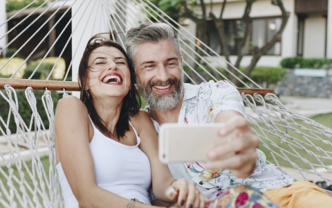 couple laughing taking a selfie on hammock