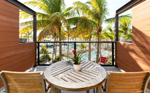 balcony overlooking the pool and marina with lots of palm trees