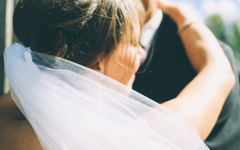 back of brides veil hugging groom