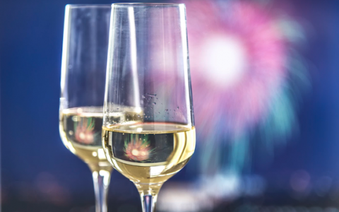 two glasses of champagne with fireworks in background