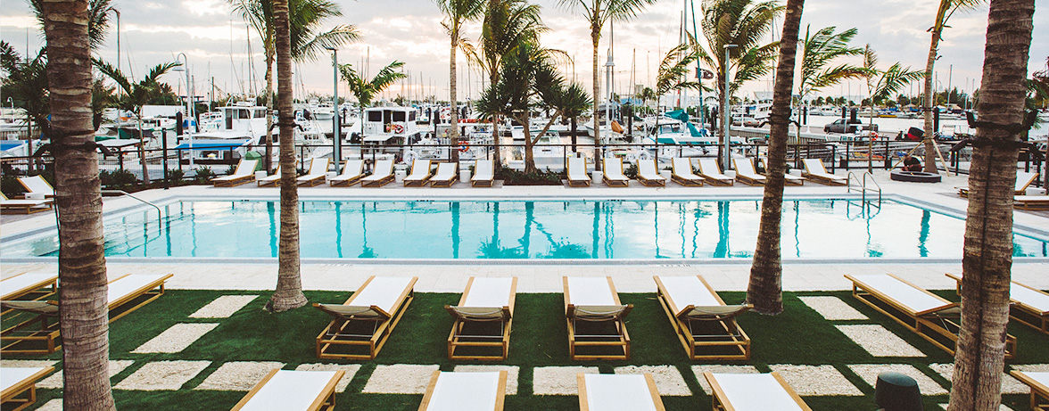 great view of the pool of property, parked boats and big palm trees around 