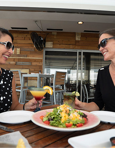 women eating lunch by the water