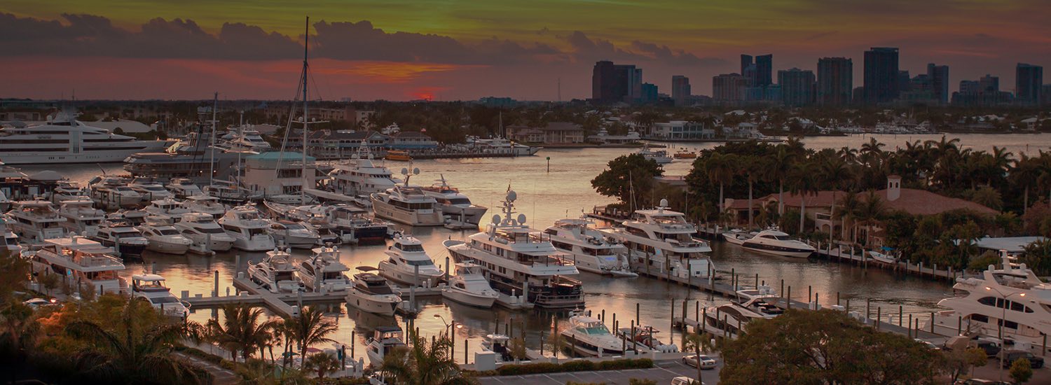 view of a marina filled with various sized boats at sunset