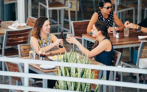Two women enjoying drinks on outdoor terrace