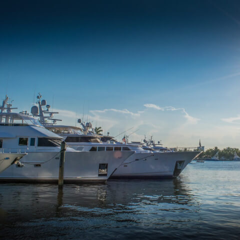 two boats docked at a marina with the view of the fort lauderdale skyline