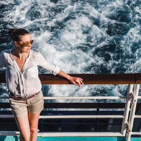 woman leaning over the rails of a boat in motion